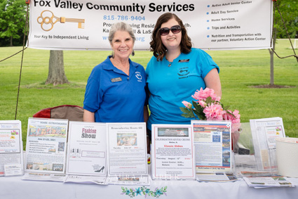 Two FVCS Workers behind table display outdoors