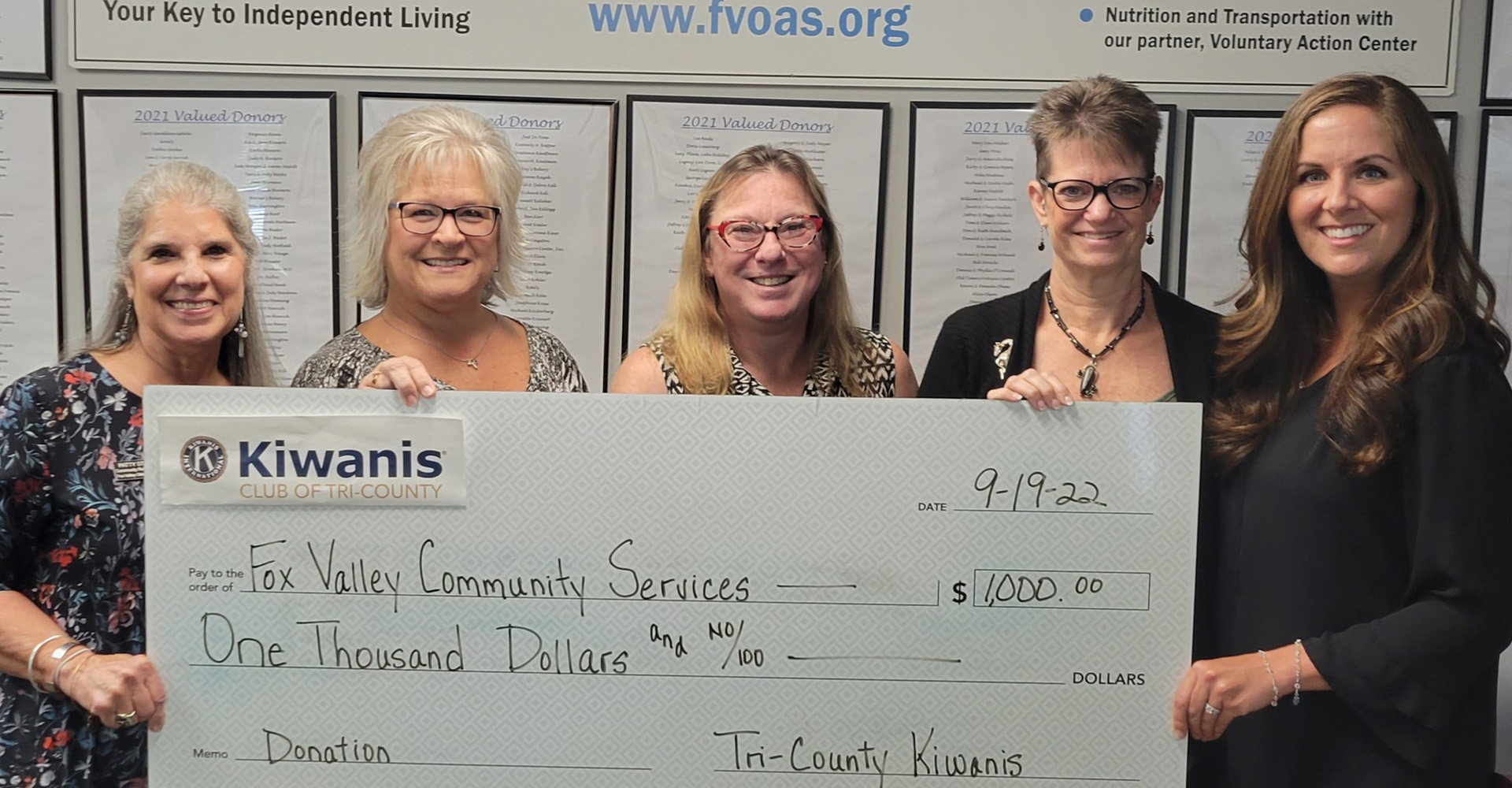 Fox Valley Community Services Group holding up large donated check from Tri-County Kiwanis for $1,000